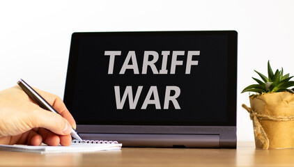 Trade tariff war symbol. Concept word Tariff war on beautiful black tablet. Businessman's hand with...