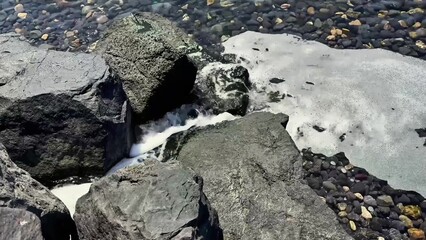 Serene and Calm Coastal Waters Gracefully Flowing Over Smooth Rocks Along the Shoreline