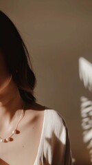 A woman on cream-colored dress adorned in a delicate  necklace and matching earrings, illuminated by soft, natural sunlight, vertical