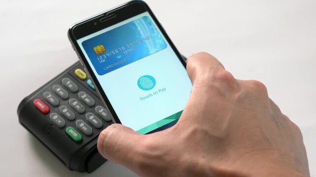A person is using a phone to pay for something at a card reader