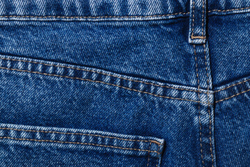 Dark blue jeans, waistband, pocket and seams on denim textile close-up