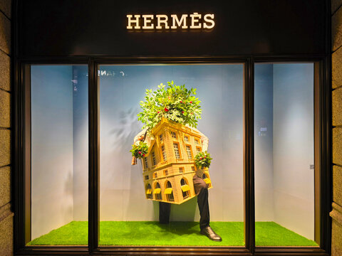 Taipei, Taiwan &ndash; August 2, 2024: Surreal Hermes Window Art Display with Anthropomorphic House and Green Plants