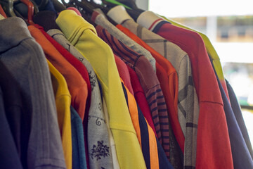 Obraz premium Assorted colorful jackets and sweaters on a clothing rack at street market