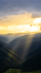 landscape dramatic dark rain clouds before a storm &mdash; play of light and shadow in the mountains, Silhouettes of mountain peaks at sunset with scenic travel background