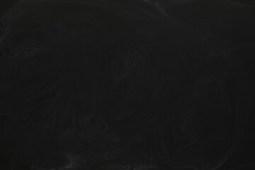 Chalk rubbed out on black chalkboard as background, closeup. Space for text