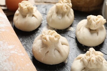 Many uncooked khinkalis (dumplings) on table, closeup