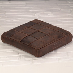 This soft green cushion features a stylish grid pattern and adds a touch of comfort and elegance to any living space. Placed on a textured white background, it complements various interior styles.