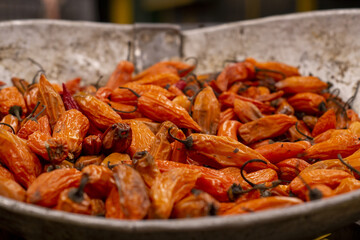 Dried orange chili peppers displayed in metal tray