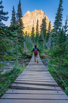 hikers crossing a swinging bridge in Glacier National Park