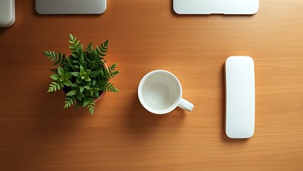 Minimalist office desk with coffee cup and plant, top-down view on warm wooden surface.