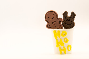 Two cookies in a glass with the words Ho ho ho with copyspace on a white background