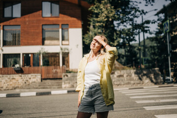 Fototapeta premium A woman stands near the road on a summer day.