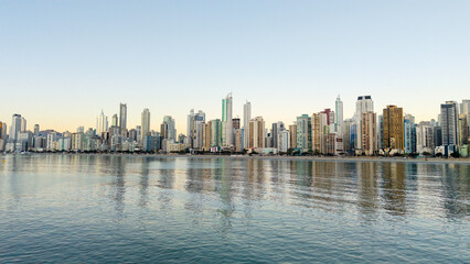 Fototapeta premium Balneario Camboriu skyline with skyscrapers reflecting on the sea at sunset, Santa Catarina, Brazil.