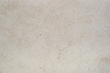 Beige textured surface with small white flecks. Empty textured background of beige tiled background.