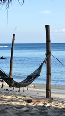Obraz premium Empty hammock on sandy beach by ocean