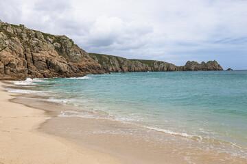 Porthcurno Beach, Cornwall UK with wide golden sand and clear Atlantic water