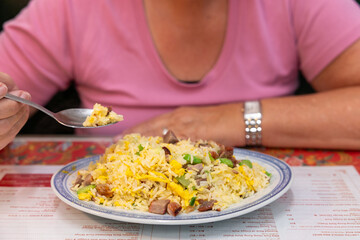 Close up of a woman eating Chinese nasi in a restaurant