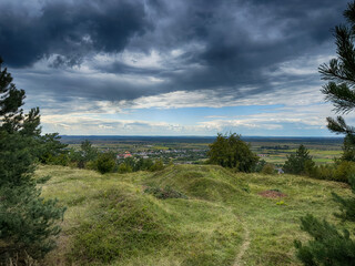 Hilltop view of village under dramatic cloudy sky. Scenic panorama of countryside village before the rain