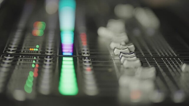 Blurred, vibrant studio mixing console with glowing lights and adjustment controls,