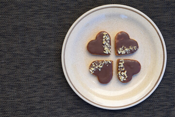 Sandwich heart shaped cookies with peanut butter, chocolate and chopped cashews