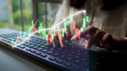 A dynamic image showcasing hands typing on a keyboard overlaid with vibrant stock market charts and...