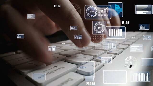 Close-up of hands typing on a keyboard with floating digital graphs and icons, symbolizing data analysis and technology in a modern workspace environment. Xenic - Powered by Adobe