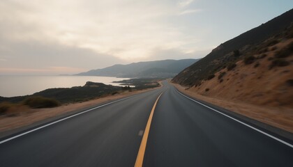 A view of a two lane highway with a view of the ocean on the left.