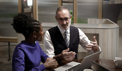 Business meeting or working in modern office. Senior executive discussing project with colleagues using laptop and online digital reports. Teamwork Leadership Strategy and Corporate Collaboration Tech