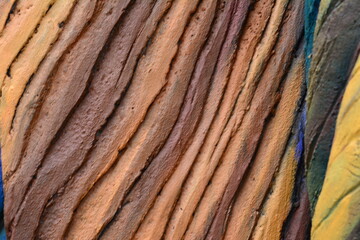 Sculpted bark with embedded leaf motifs and green-blue coloration.