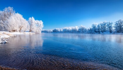 tranquil winter lake scene with snowy shoreline and frosty trees under a blue sky capturing the serene beauty of nature in a peaceful landscape
