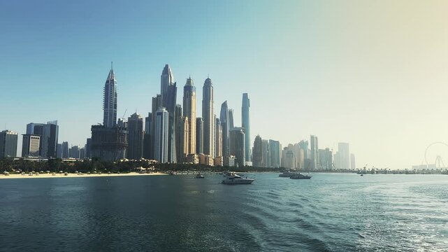 Dubai Marina with anchored luxury yacht boats and modern business skyscrapers under sunlight, no logos