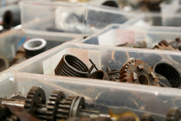 Various motorcycle engine parts, made of metal, steel, or iron. You can see engine blocks, cylinders, sprockets, headlights, speedometers, etc.