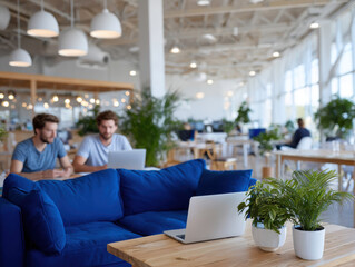 Coworkers using laptops in modern open plan office