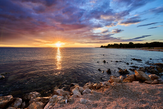 Colorful sunset over the beach in Mandre on Pag Island, Croatia, with calm sea and Mediterranean charm.