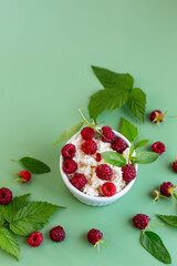 Summer cottage cheese with raspberries and green leaves on top