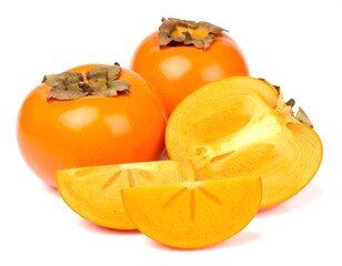 Ripe persimmons displayed with sliced segments on a white surface
