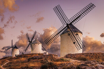 Obraz premium Historic windmills of Consuegra under a dramatic sunset sky, Spain