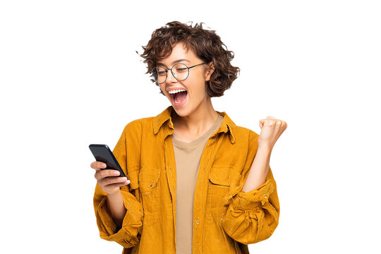 Excited Woman in Yellow Looks at Phone. Authentic shot ideal for social media, advertising.