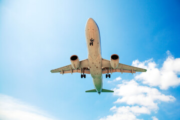 Passenger airplane flying in the sky. Travel background with airplane flying in the blue sky. View directly in front. Passenger plane landing.