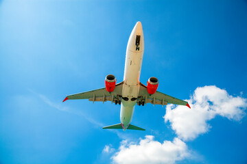 Passenger airplane flying in the sky. Travel background with airplane flying in the blue sky. View directly in front. Passenger plane landing.