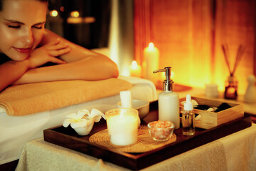Caucasian woman customer enjoying relaxing anti-stress spa massage and pampering with beauty skin recreation leisure in warm candle lighting ambient salon spa at luxury resort or hotel. Quiescent