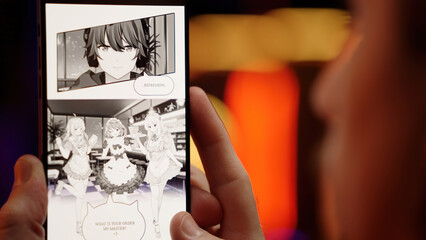 Person reading cute maid girls black and white manga comic How I Meet my Waifu on smartphone over shoulder view