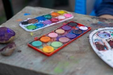Creative exploration with watercolors on a wooden table during an afternoon crafting session in a sunny outdoor space