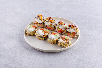 Gourmet salmon sushi rolls served on a black plate with garnishes, ready for a fine dining experience