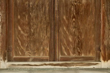 伝統的な日本建築の背景用素材。経年で色褪せた木製の門扉のクローズアップ。