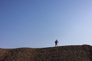 Individual explores a rocky landscape under a clear sky during daylight hours