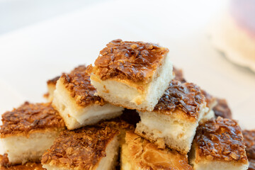 German bee sting cake (Bienenstich) snacks on a table. Close-up of the sweet dessert pieces piled up. Food to celebrate an event. Popular pastry in Germany.