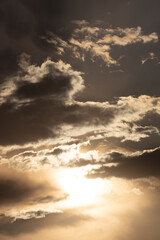 Obraz premium Sunset clouds reflect orange and gold hues over a serene sky at dusk, creating a tranquil atmosphere near the horizon