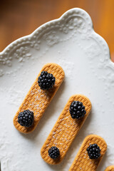 Delicious dessert featuring sweet cookies topped with fresh blackberries on an elegant plate in a cozy setting
