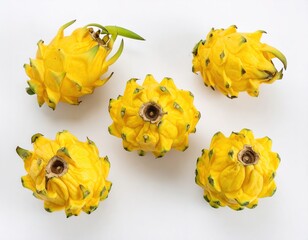 Flat lay close-up of five fresh whole yellow dragon fruits neatly arranged on a pristine white background, showcasing their unique vibrant color and texture in high detail